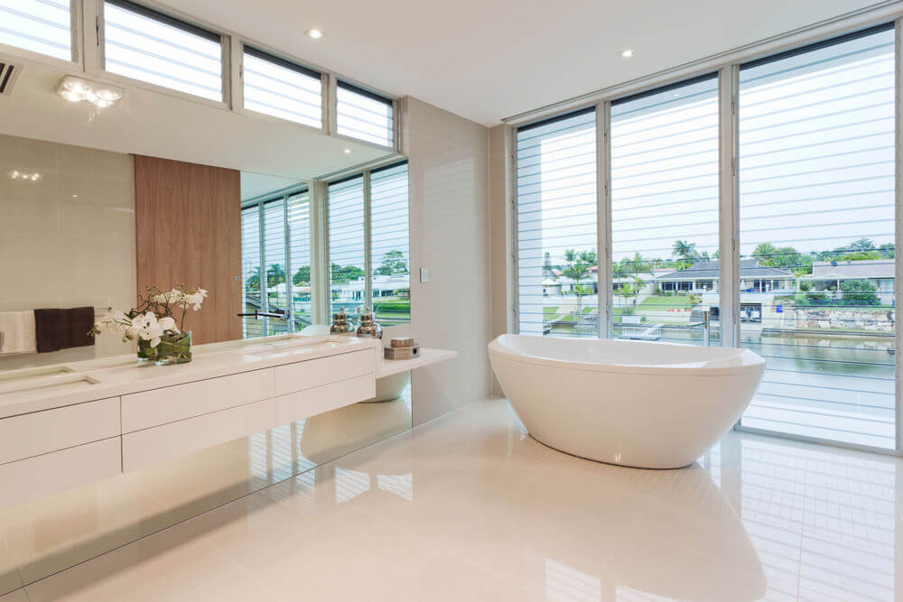 A very nice white bathroom with a good view that is reflecting off what white bathroom floor tiles